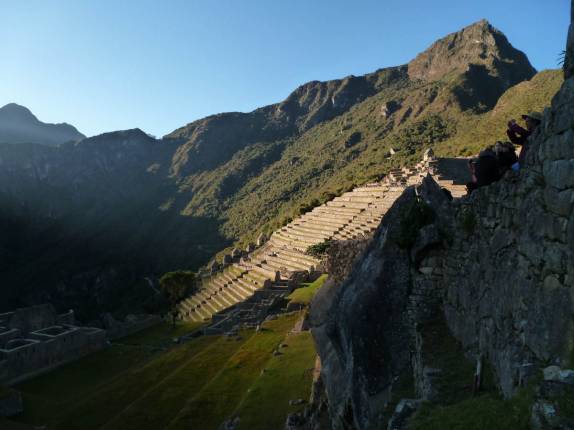 O sol começa a iluminar as ruínas de Machu Picchu, no Peru